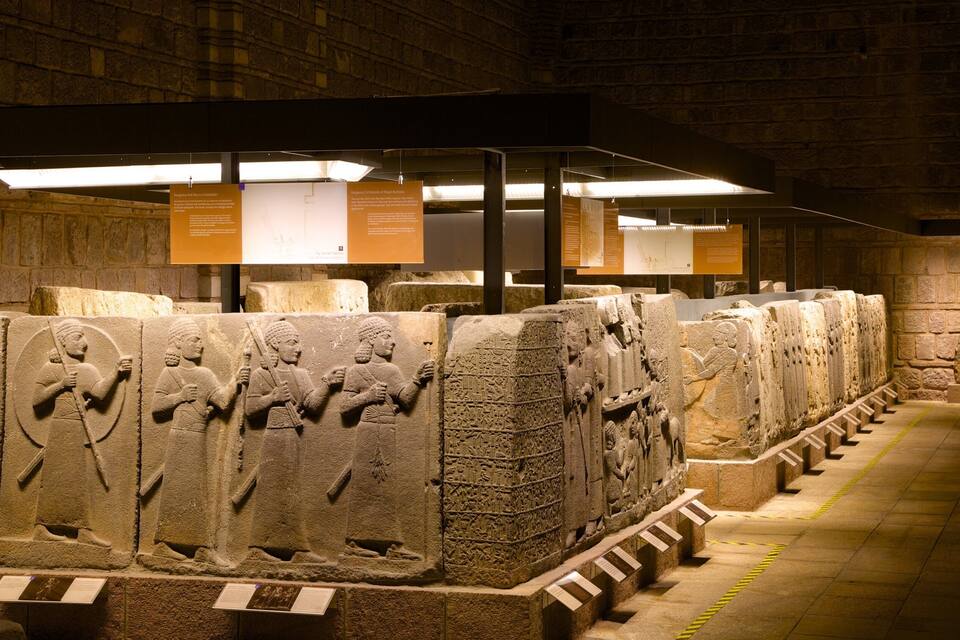Talluts antics de pedra amb inscripcions, exposats en un museu acompanyats de cartells informatius.