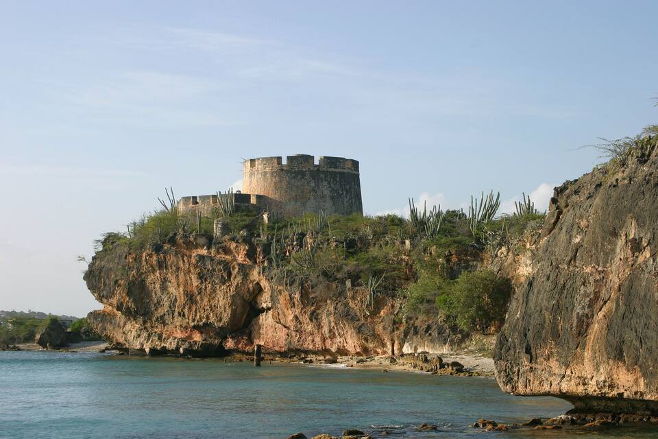 Un castillo costero en un acantilado con vistas al mar.