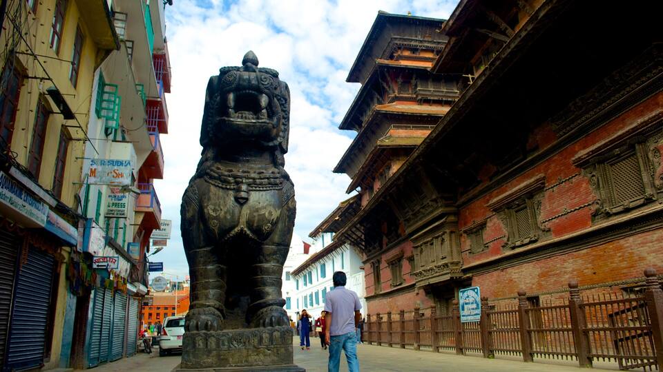 A street with traditional buildings and a large stone lion statue.
