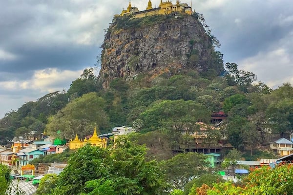 A temple on a hill with a cloudy sky.