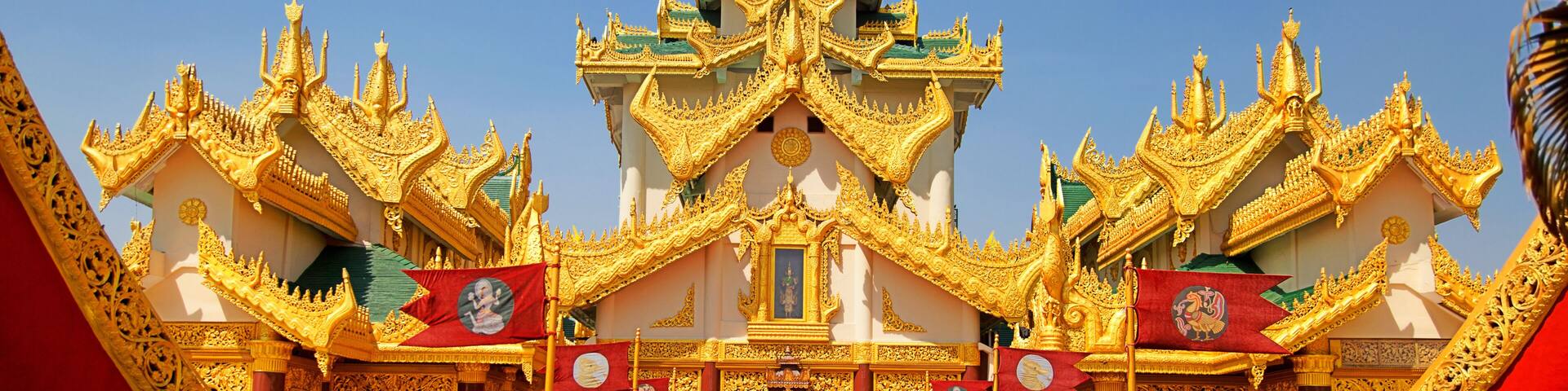 A golden temple with intricate architecture and a red carpet leading to the entrance.