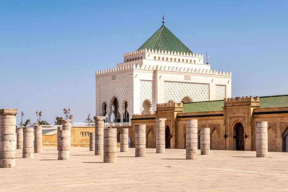 A large, historic building with a green roof and intricate architectural details.
