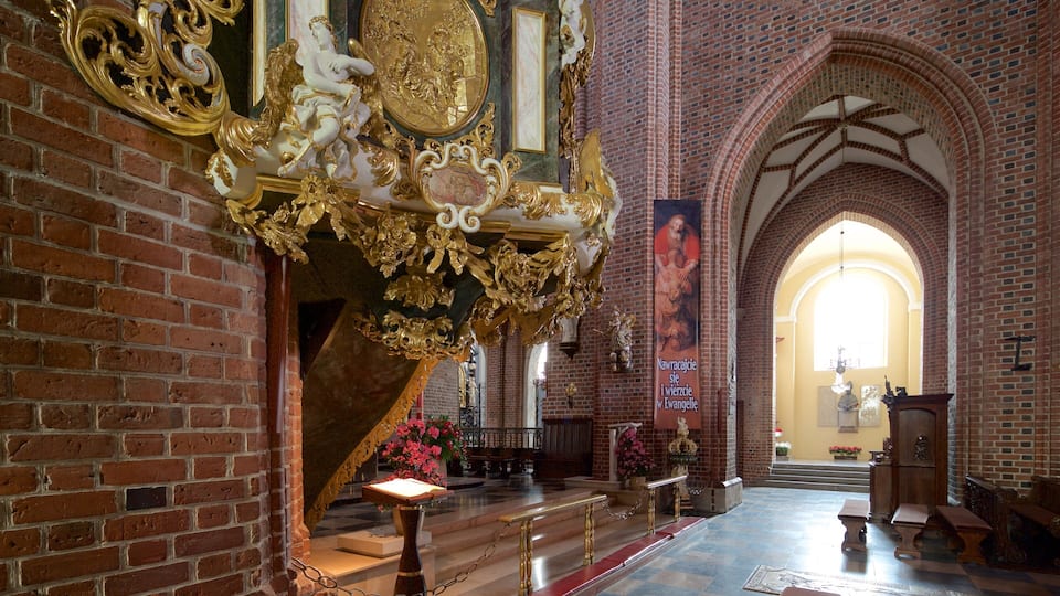 An ornate church interior with brick walls, golden decorations, and a large mural.