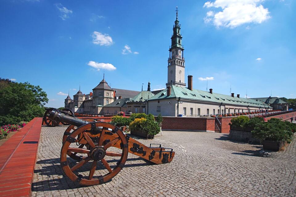 Un bâtiment historique doté d’une haute tour et d’un canon en premier plan.