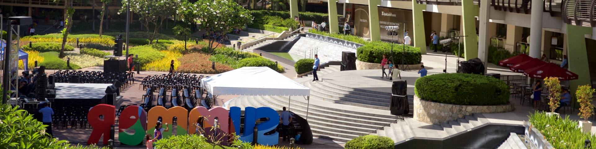 A modern urban plaza with a stage, seating, and a large white canopy structure.