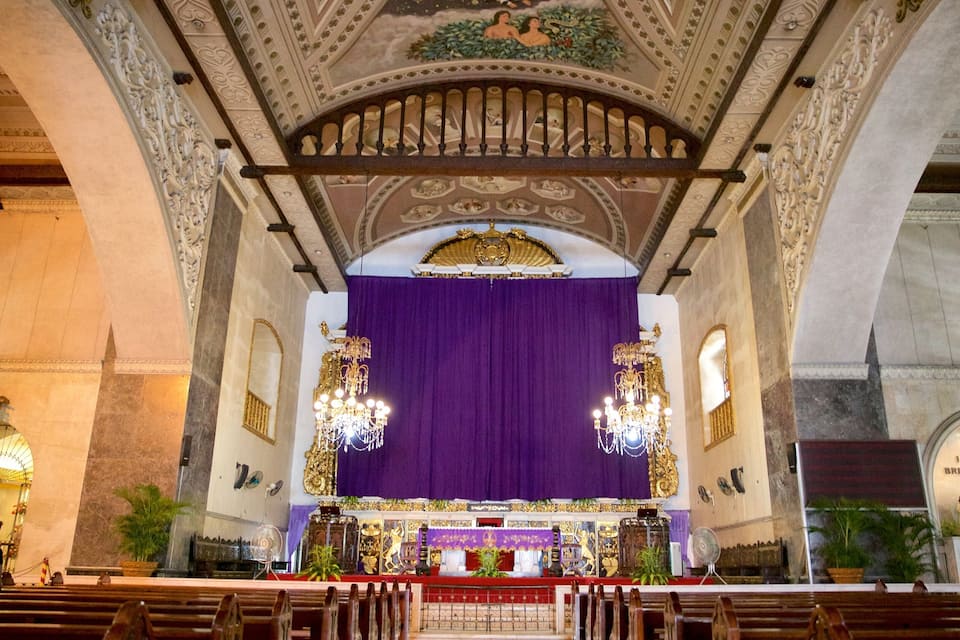 An ornate church interior with a purple altar, chandeliers, and detailed ceiling artwork.