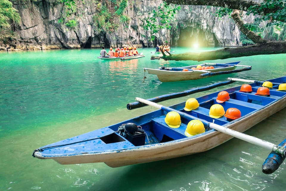 A turquoise river with boats and people.