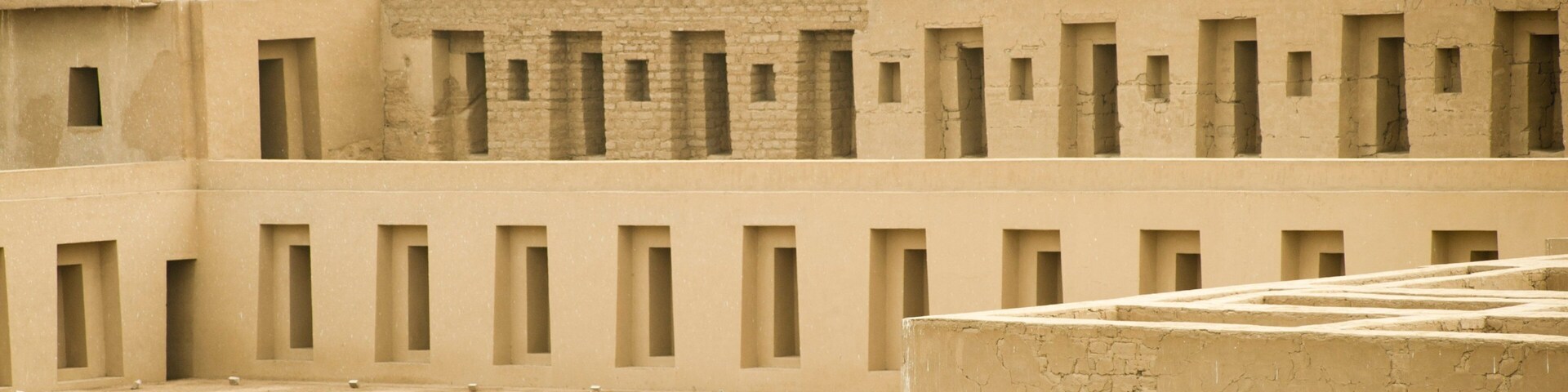 A traditional mud-brick building with multiple small windows and a flat roof.