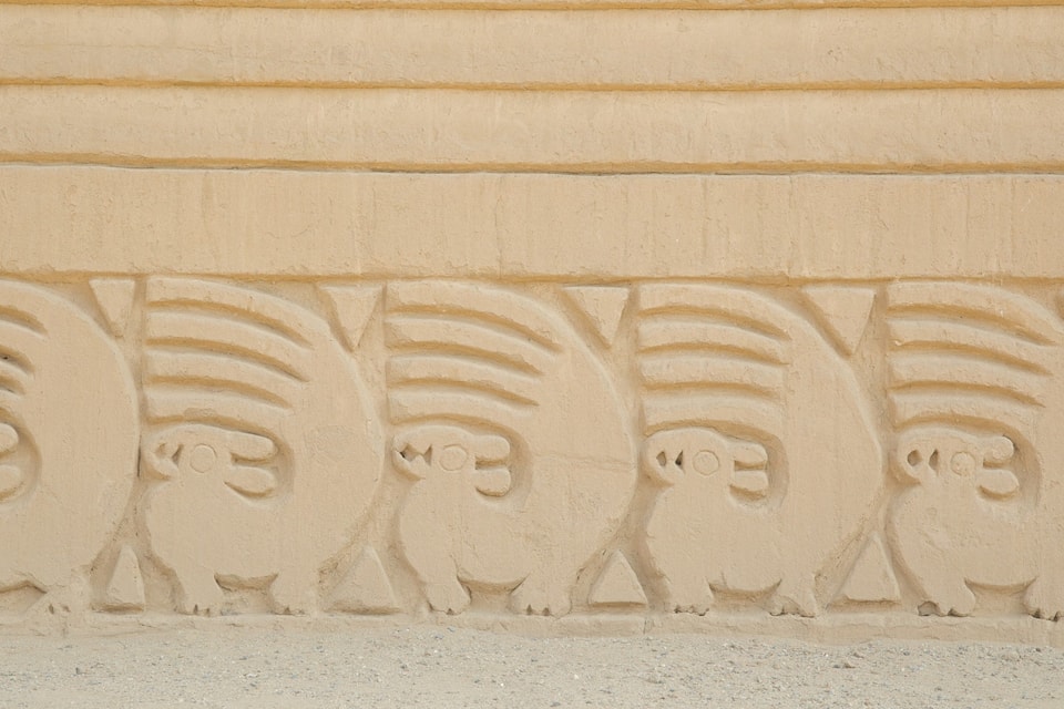 A row of carved animal figures on a wall.