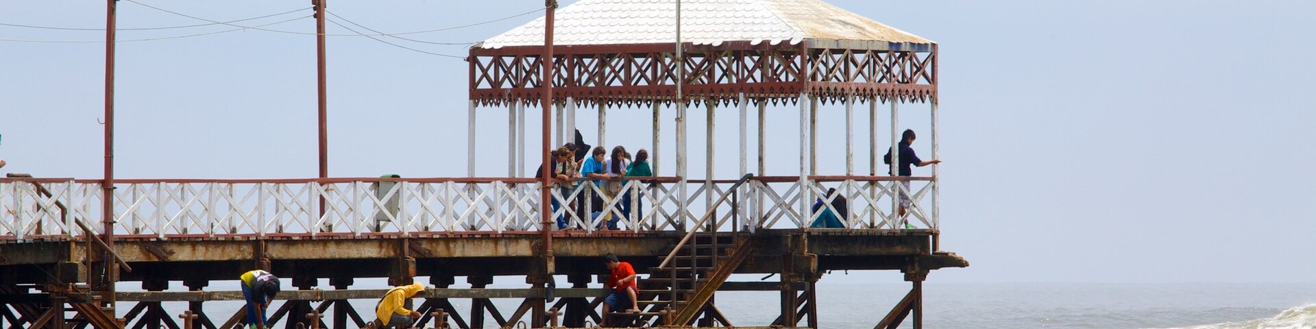 Un muelle con un área de observación techada y gente caminando.