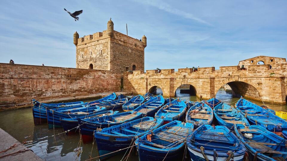 Fort of Essaouira in Morocco on a sunny day with blue boats on the water
