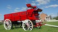 A red fire engine with 'Kohls Ranch' and 'Grant' written on it, parked on grass with a building in the background.