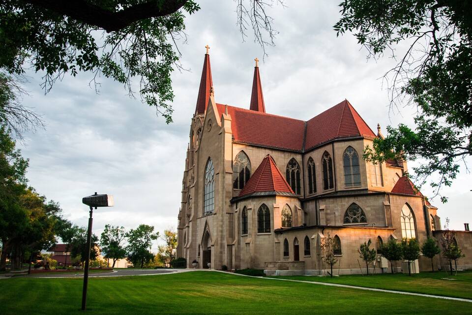 A large church with a red roof and two tall spires.