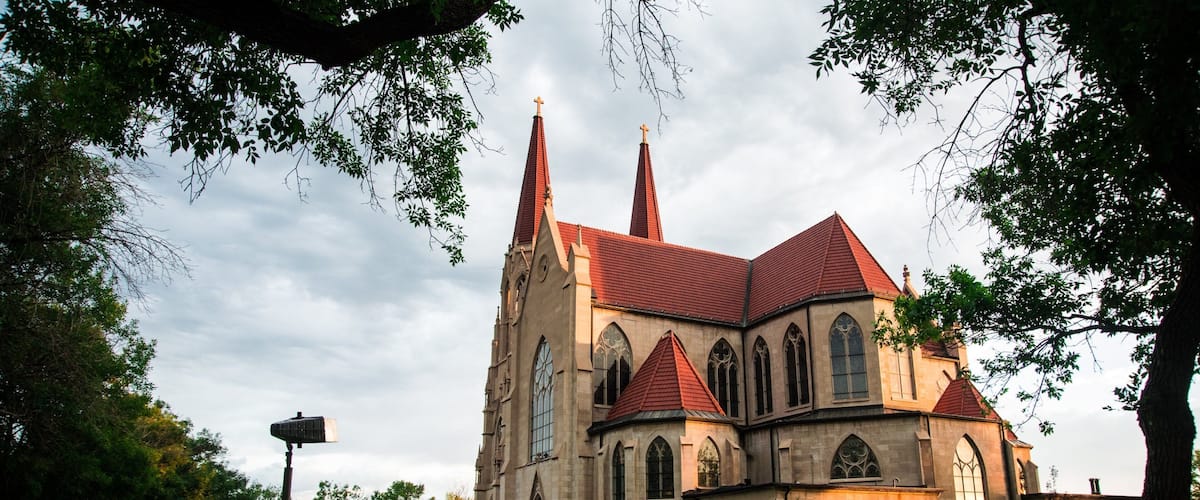A large church with a red roof and two tall spires.