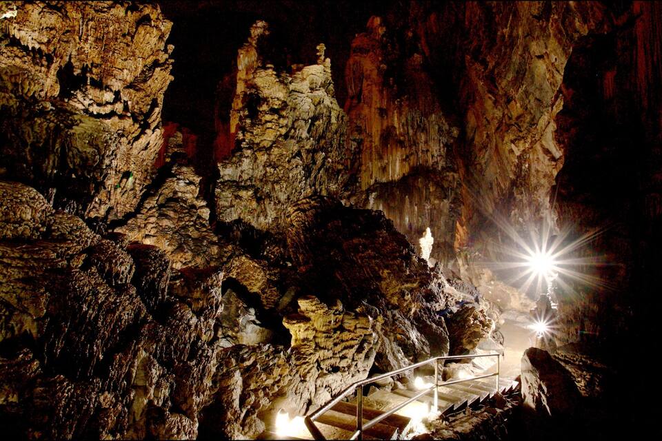 A cave with stalactites and a staircase.