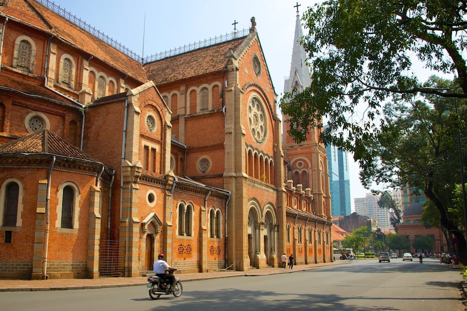 Uma igreja de tijolos imponente com uma torre alta e várias janelas em arco.