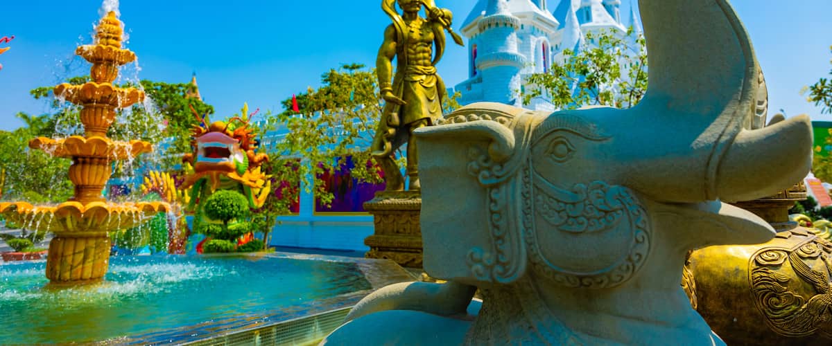 A water fountain, a statue, and a castle-like structure.