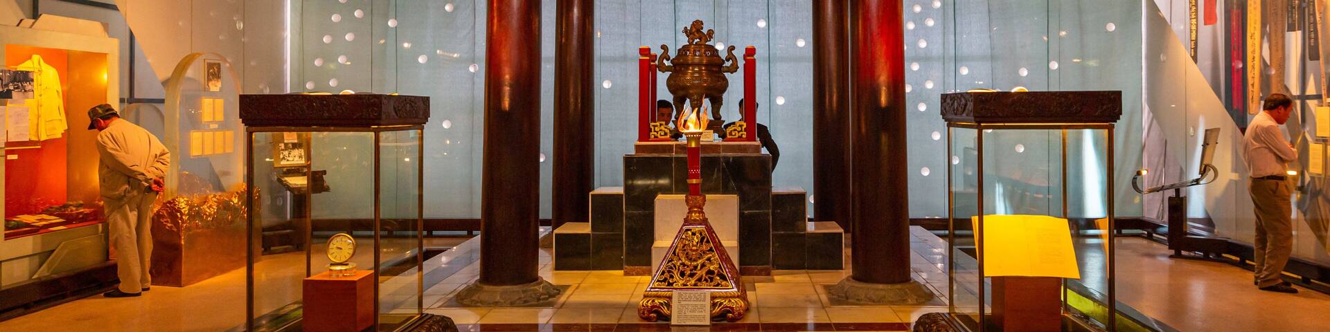 A traditional temple interior with a central altar, wooden pillars, and a tiled roof.