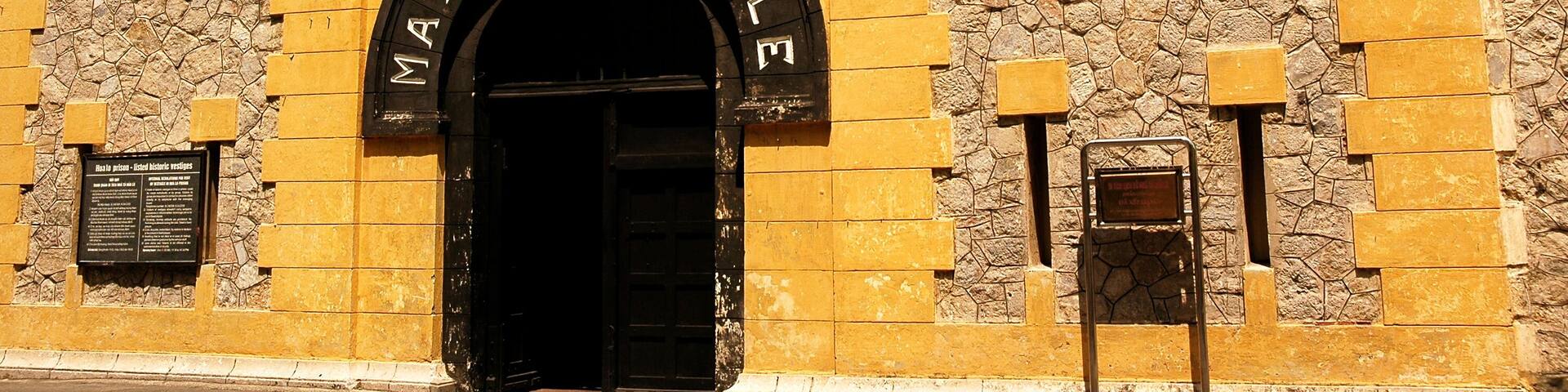 A historic building with a stone facade and a black archway labeled 'MAISON CENTRALE.'