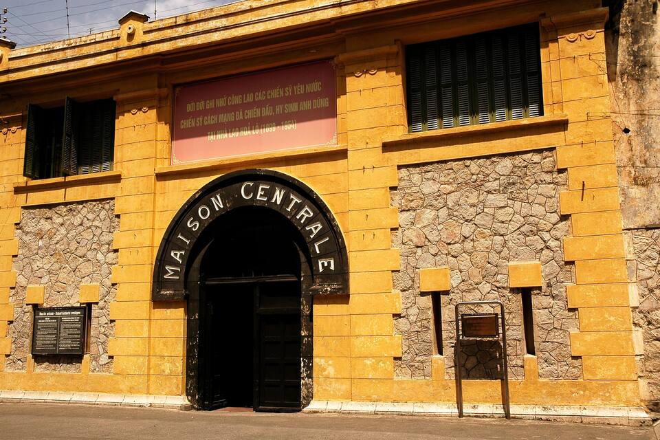 A historic building with a stone facade and a black archway labeled 'MAISON CENTRALE.'