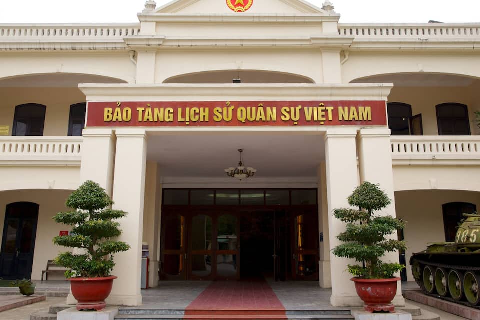 A building with a red banner reading "BAO TANG LICH SU QUAN SY VIET NAM".