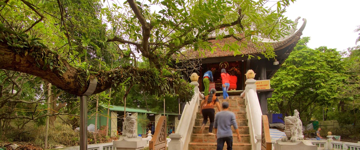 One Pillar Pagoda which includes a temple or place of worship as well as a small group of people