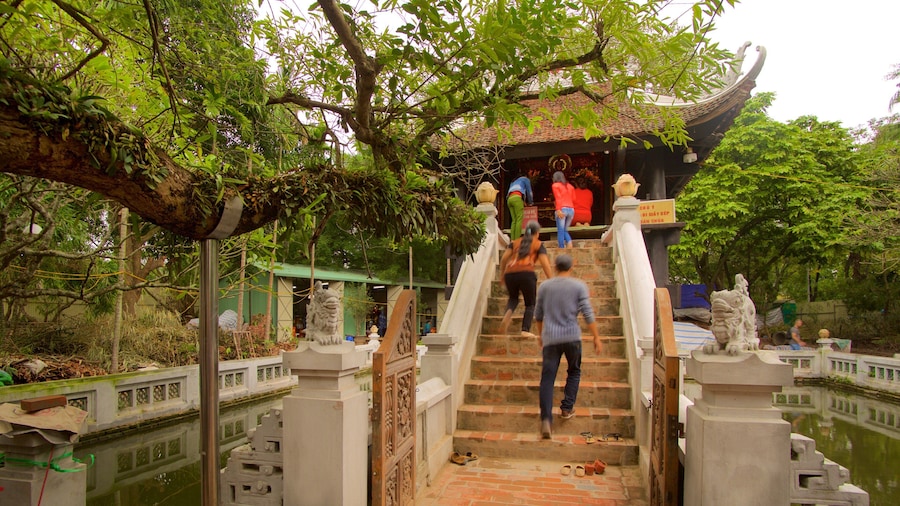 One Pillar Pagoda which includes a temple or place of worship as well as a small group of people