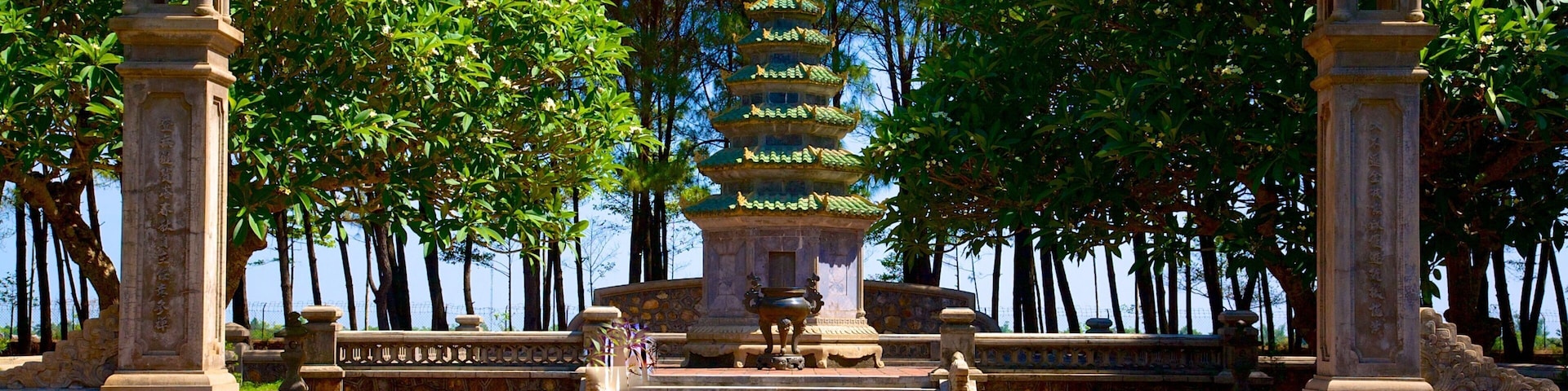 Una pagoda rodeada de árboles y faroles de piedra.