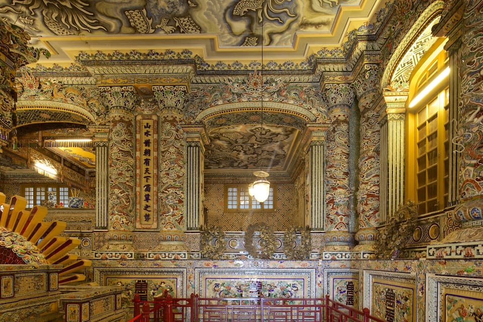 Un interior ornamentado con murales detallados, columnas y elementos arquitectónicos tradicionales chinos.