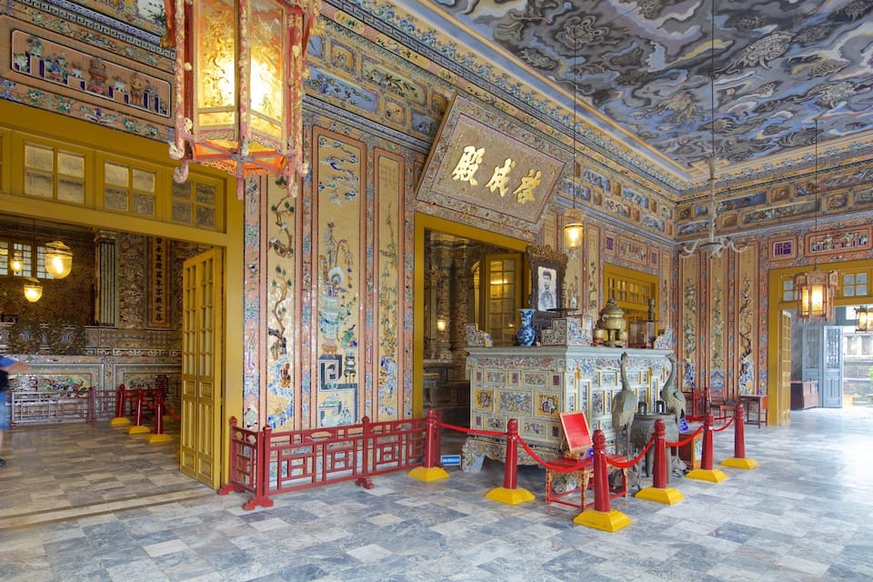Un interno finemente decorato con elementi architettonici cinesi tradizionali, tra cui affreschi elaborati e un altare di rilievo.