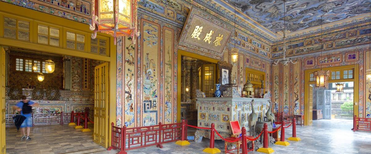 An ornately decorated interior with traditional Chinese architectural elements, including intricate murals and a prominent altar.