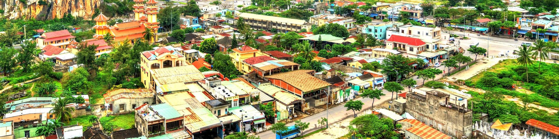 A town nestled between two large mountains, with a prominent temple and a mix of residential and commercial buildings.