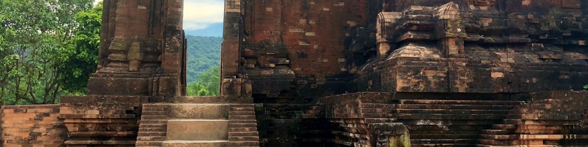 An ancient stone structure with a large doorway and a staircase leading up to it.