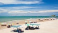 A beach with umbrellas, chairs, and a distant island.