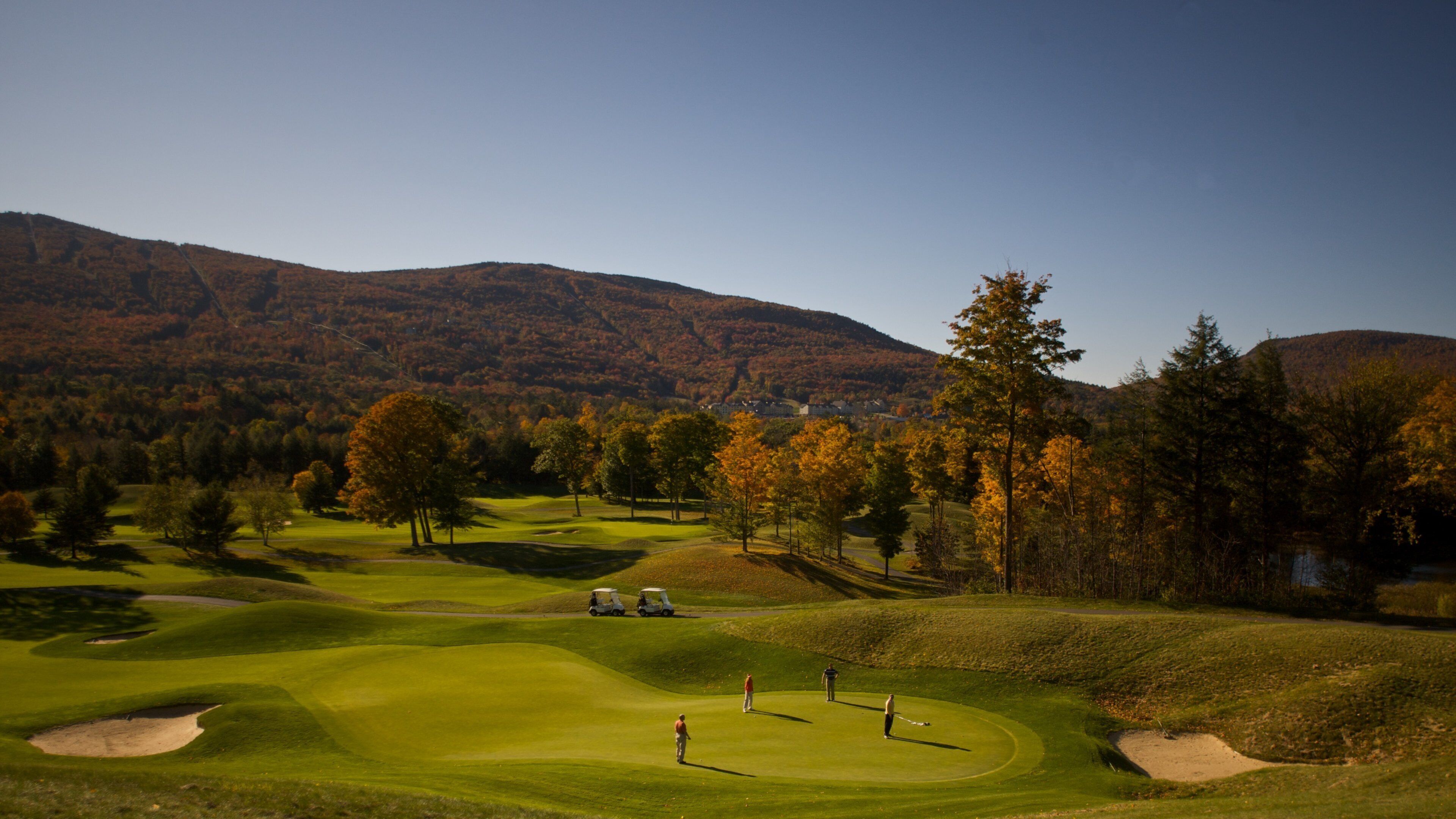 Okemo Valley Golf Club showing fall colors and golf as well as a small group of people