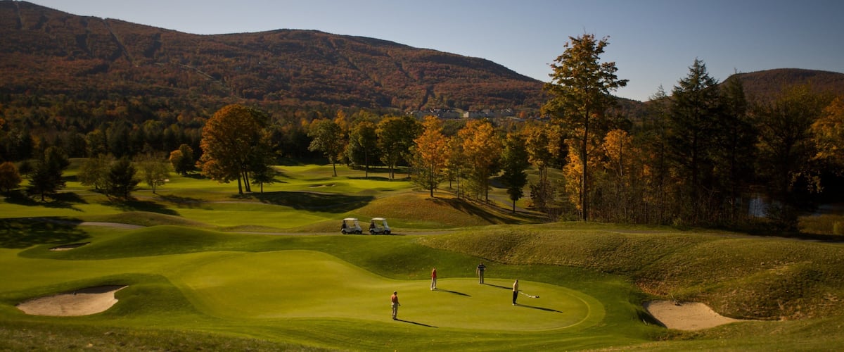 Okemo Valley Golf Club showing fall colors and golf as well as a small group of people