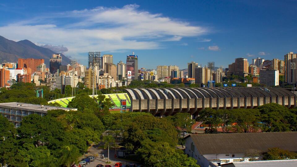 A cityscape with a stadium, high-rise buildings, and a mountain in the background.