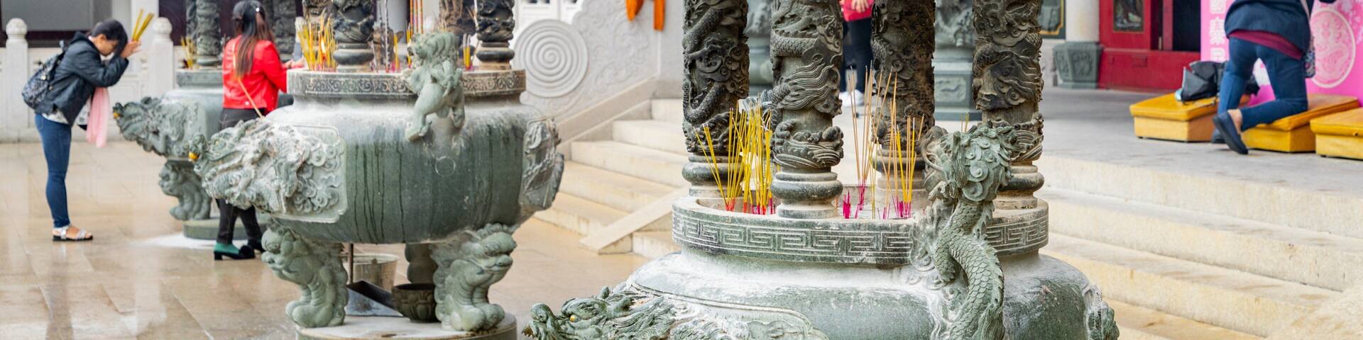 Un templo con estatuas de leones de piedra ricamente decoradas y quemadores de incienso.