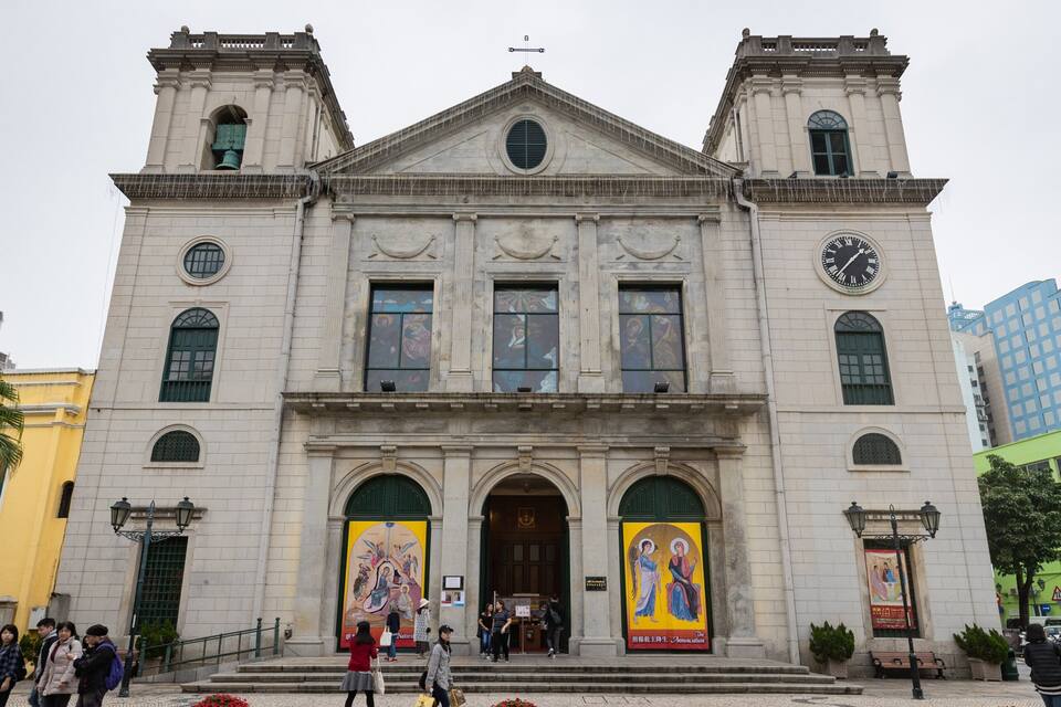 A historic church with two towers, large arched windows, and a clock.