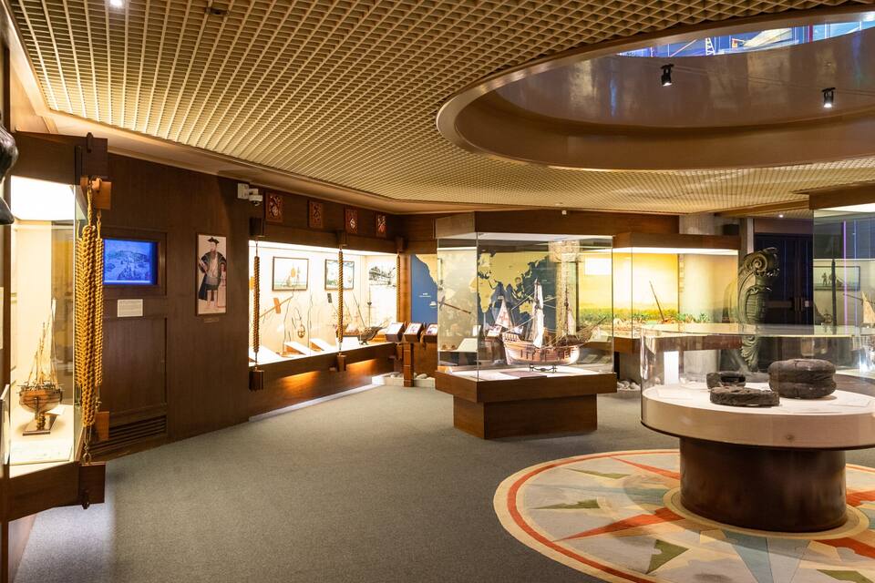 A museum interior with exhibits including maritime artifacts, a globe, and historical paintings.