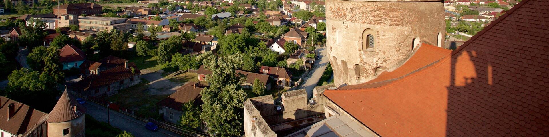 Castelo Hunedoara que inclui arquitetura de patrimônio e uma cidade pequena ou vila