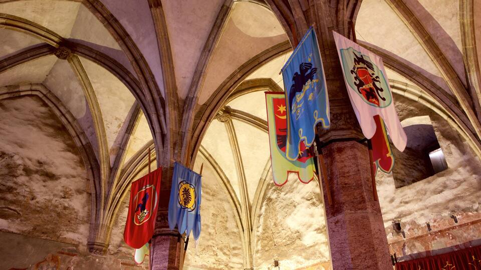 A cathedral interior with high vaulted ceilings and stained glass windows.