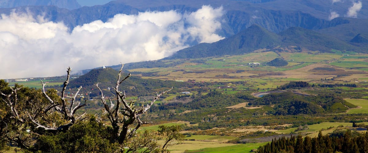 A mountainous landscape with a valley, a river, and a bridge.