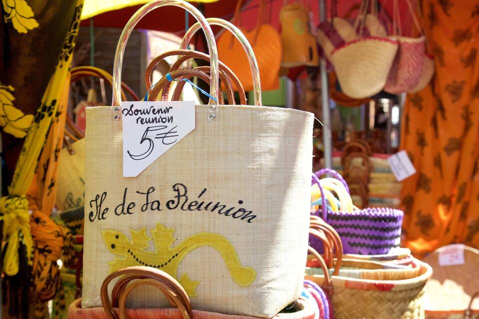 Un puesto de mercado con una bolsa blanca que lleva la etiqueta "Le de La Reine" a 5€.