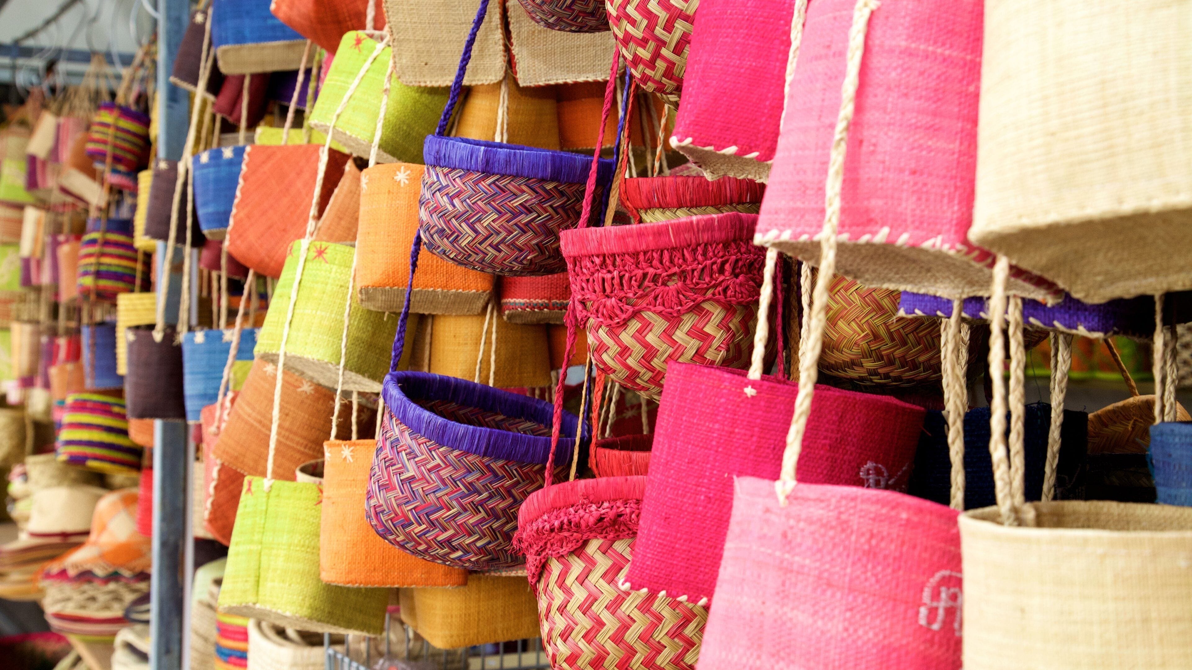 A variety of colorful woven baskets hanging in a market.