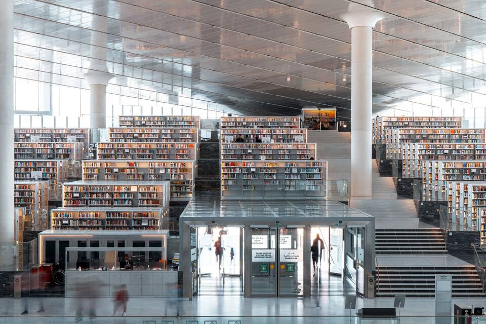 Une bibliothèque moderne, dotée de plusieurs étages d’étagères et d’un escalier central.