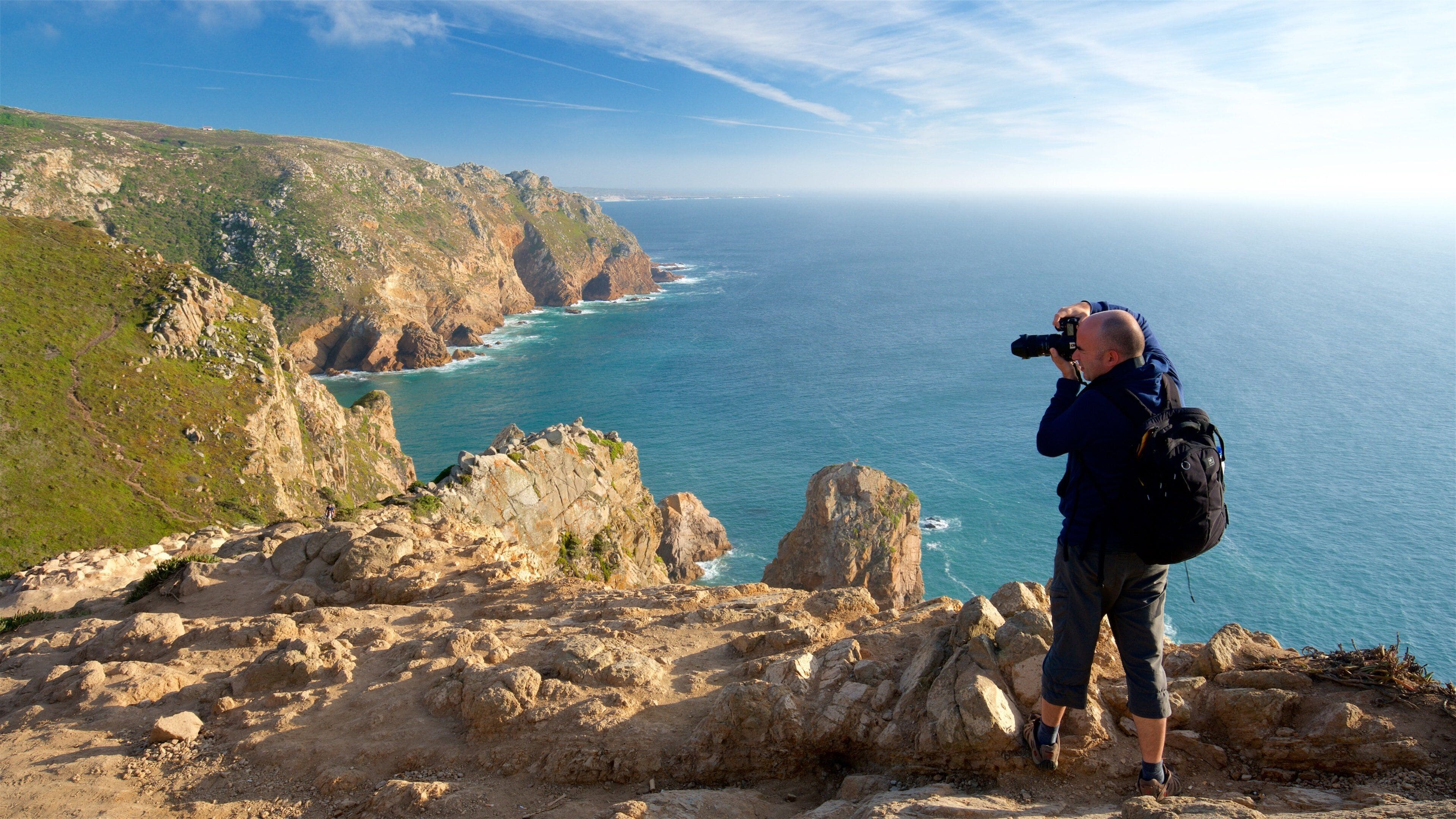 Cabo de la Roca que incluye vistas de una costa y litoral rocoso y también un hombre