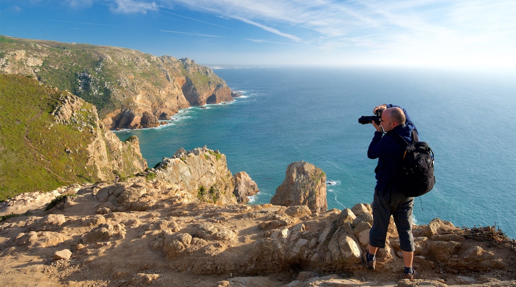 Cabo de la Roca que incluye vistas de una costa y litoral rocoso y también un hombre
