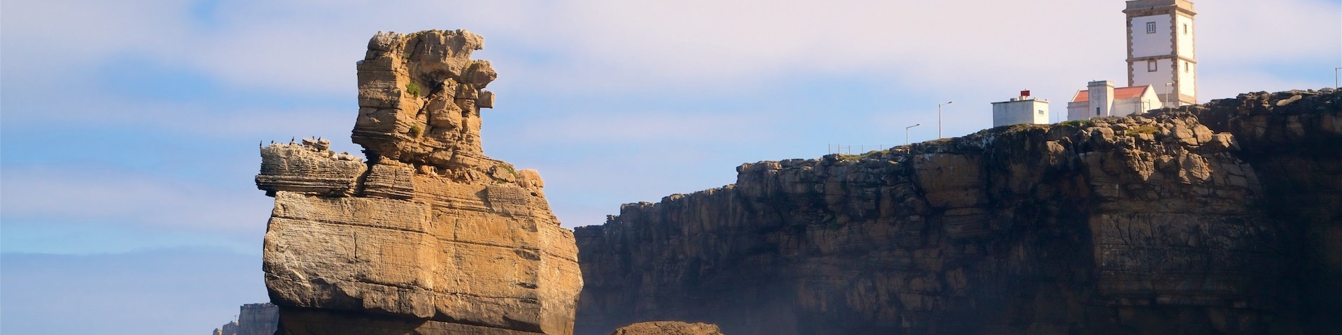 Cabo Carvoeiro featuring a lighthouse, general coastal views and rugged coastline