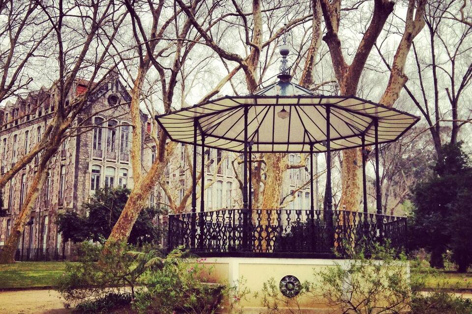 Un mirador en un parque con árboles y un edificio al fondo.